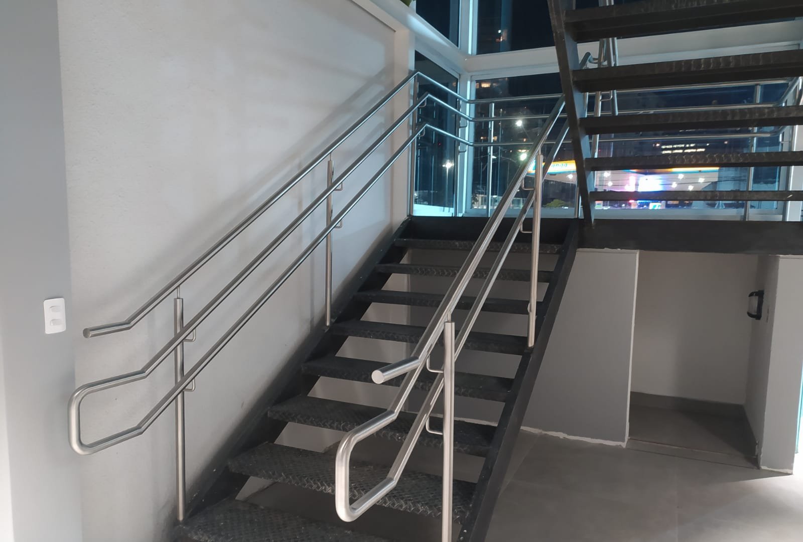 Escada metálica com corrimão de inox em prédio comercial